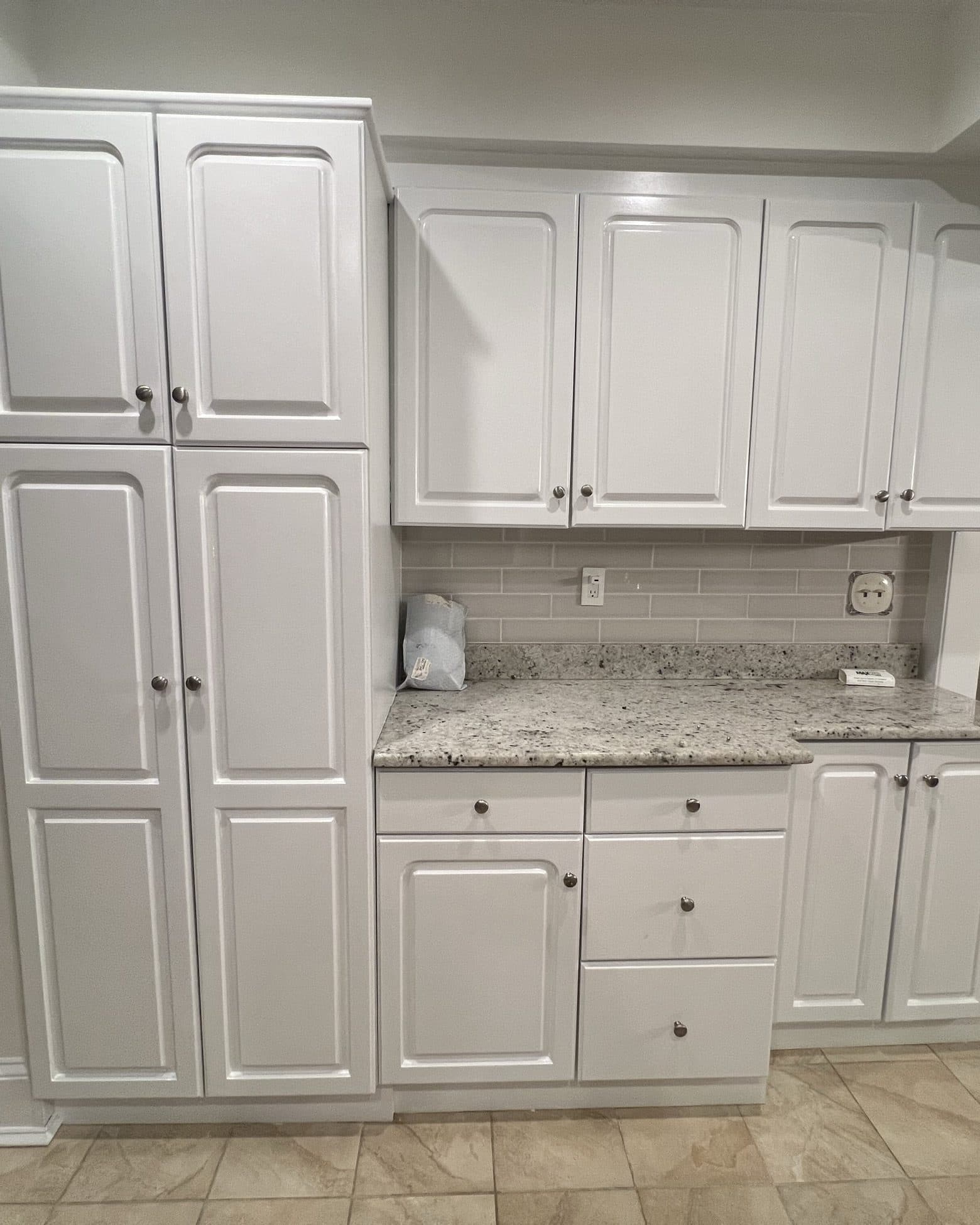 Floor-to-ceiling white cabinetry with a granite counter