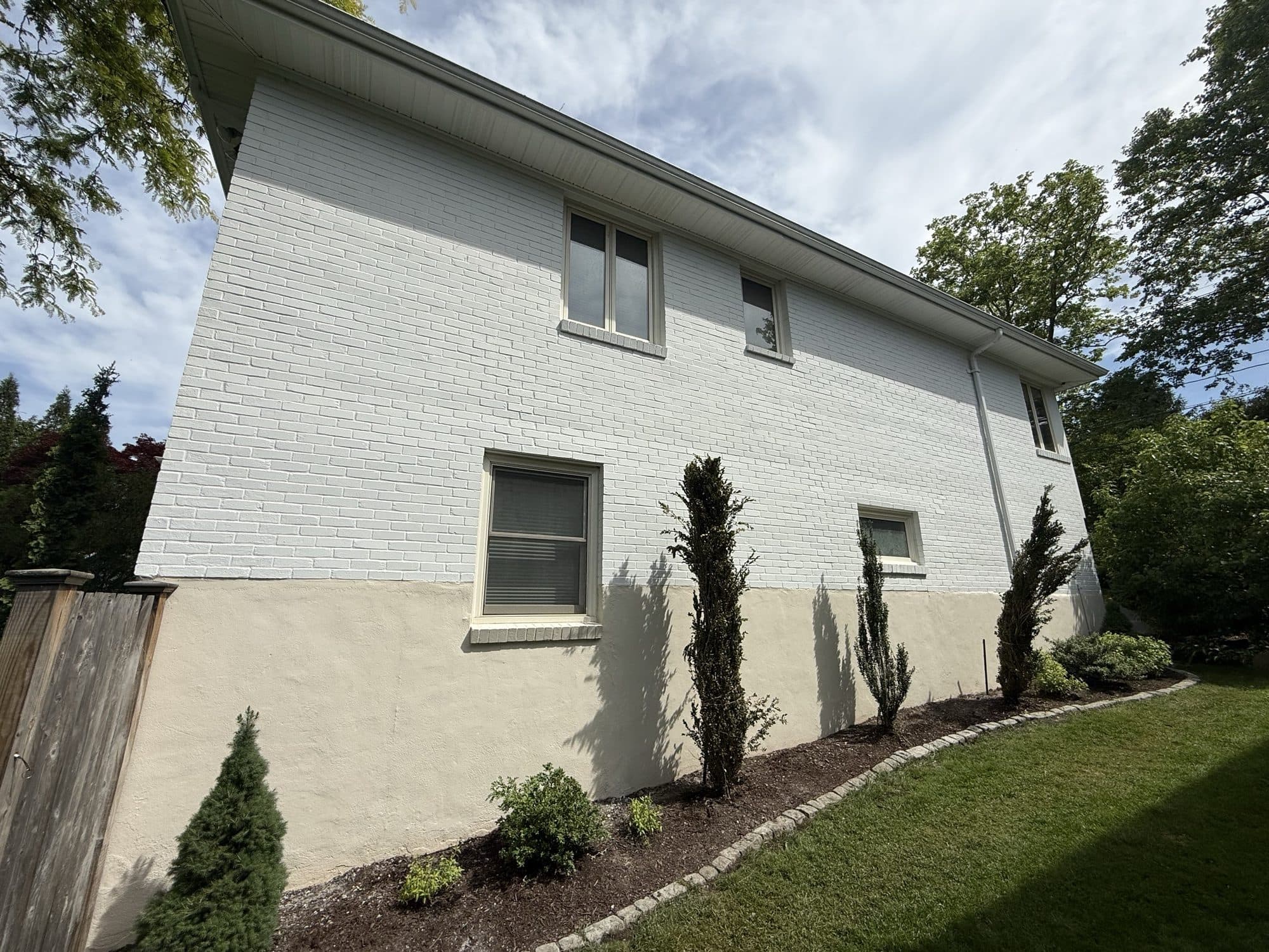 Painted white brick exterior with fresh landscaping